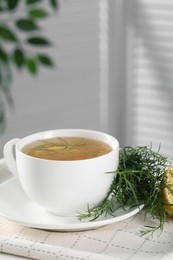 Aromatic herbal tea and fresh tarragon sprigs on table. Space for text