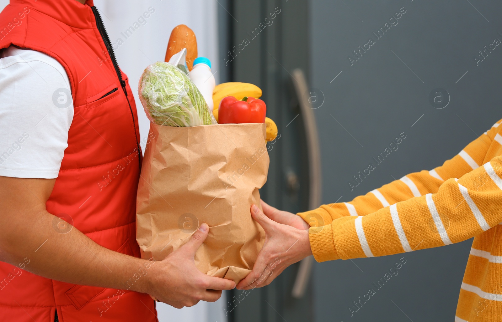 Photo of Male courier delivering food to client indoors, closeup