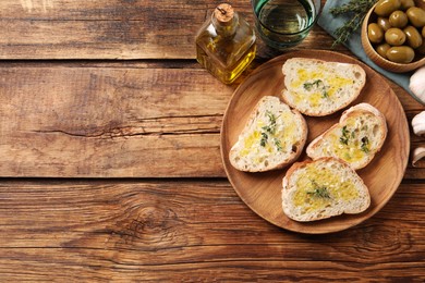 Photo of Tasty bruschettas with oil and thyme on wooden table, flat lay. Space for text