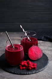 Slate plate with glasses of beet smoothies on table