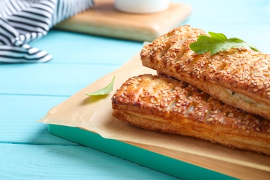 Fresh delicious puff pastry served on light blue wooden table, closeup