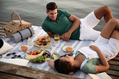 Photo of Happy couple spending time on pier at picnic