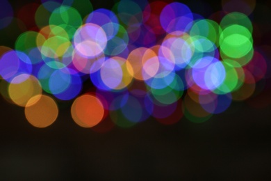 Photo of Blurred view of colorful Christmas lights on dark background