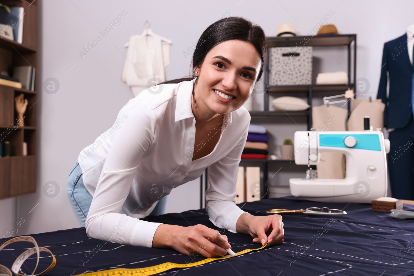 Photo of Dressmaker marking fabric with chalk in workshop