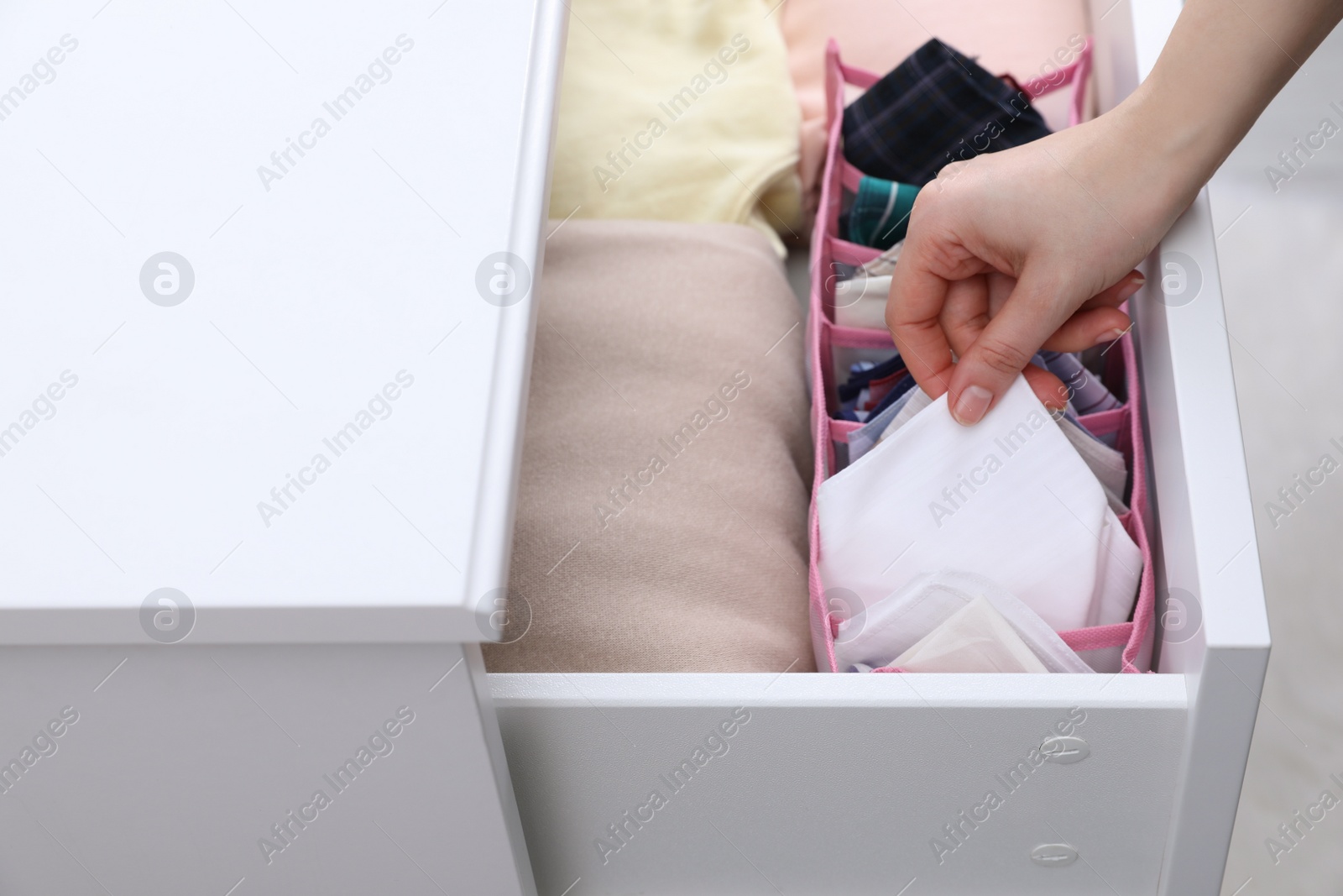 Photo of Woman taking handkerchief from drawer at home, closeup