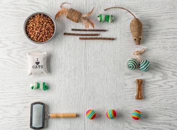 Flat lay composition with cat accessories and food on wooden background