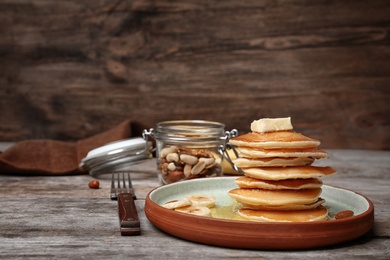 Tasty pancakes with honey and banana on table