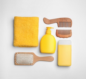 Flat lay composition with hair cosmetic products and tools on white background