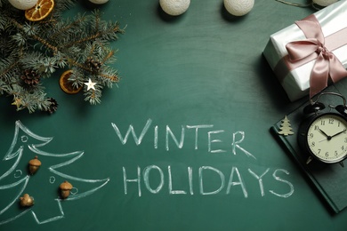 Photo of Flat lay composition with text Winter Holidays and Christmas decor on green chalkboard