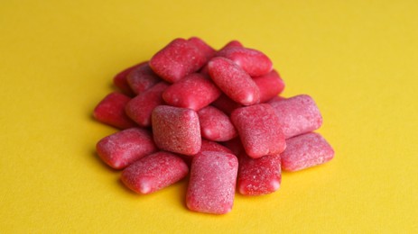 Photo of Pile of sweet chewing gums on yellow background