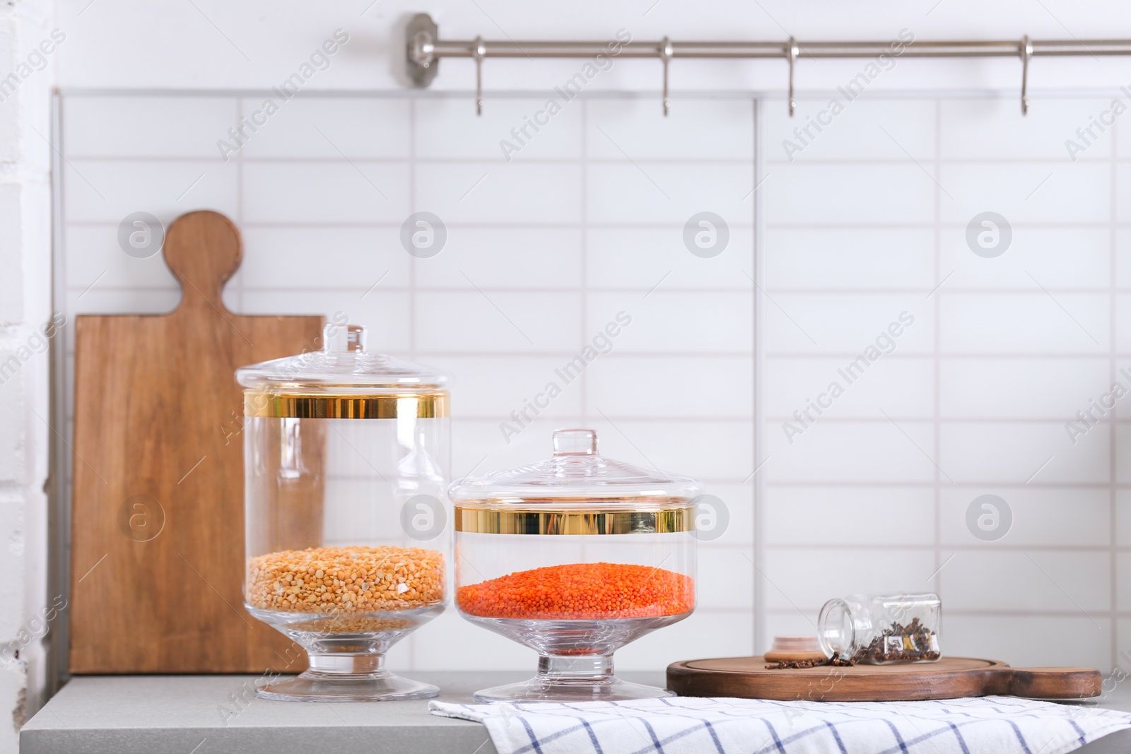 Photo of Jars with cereals on light grey table in modern kitchen