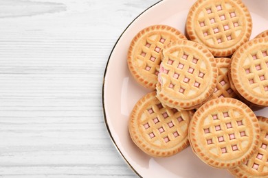 Photo of Tasty sandwich cookies with cream on white wooden table, top view. Space for text