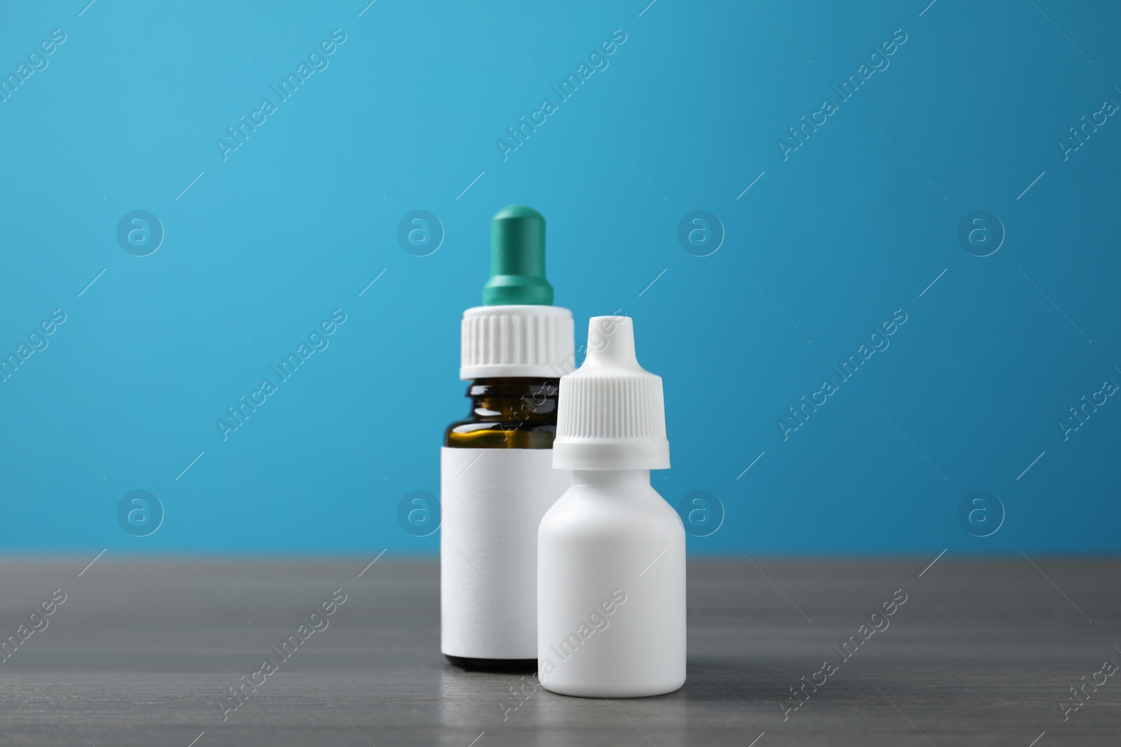 Photo of Bottles of nasal sprays on grey wooden table