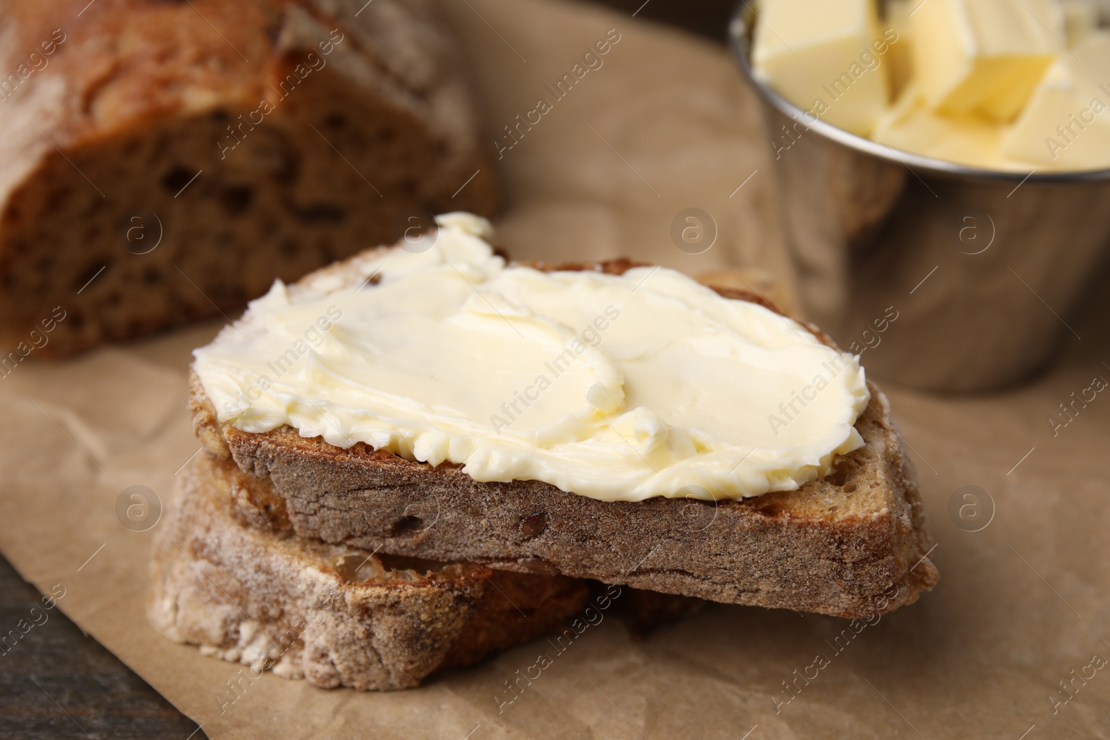 Photo of Slices of bread with tasty butter on table, closeup