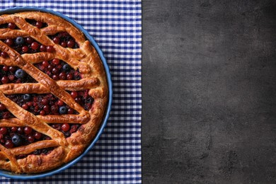 Delicious currant pie and fresh berries on grey table, top view. Space for text