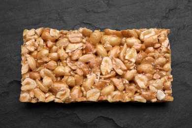 Photo of Delicious peanut bar (kozinaki) on black table, top view
