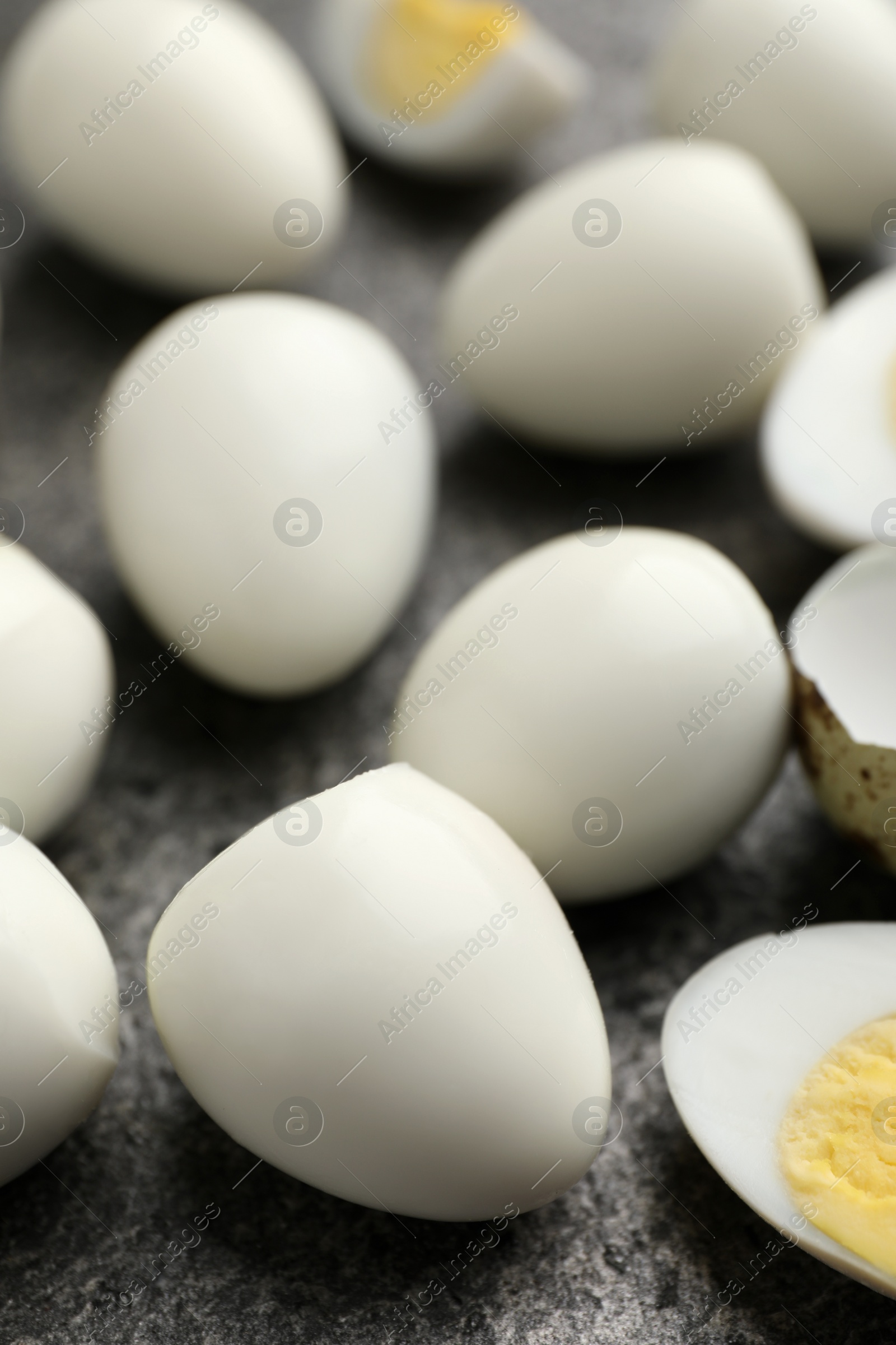 Photo of Peeled hard boiled quail eggs on grey table, closeup