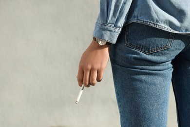 Woman with cigarette outdoors, closeup. Space for text