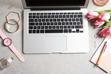 Photo of Flat lay composition with laptop and flowers on table. Woman's workplace