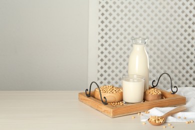 Photo of Soy milk and beans on wooden table, space for text