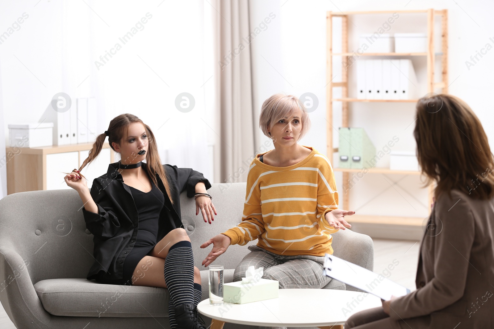 Photo of Psychotherapist working with teenage goth girl and her mother in office