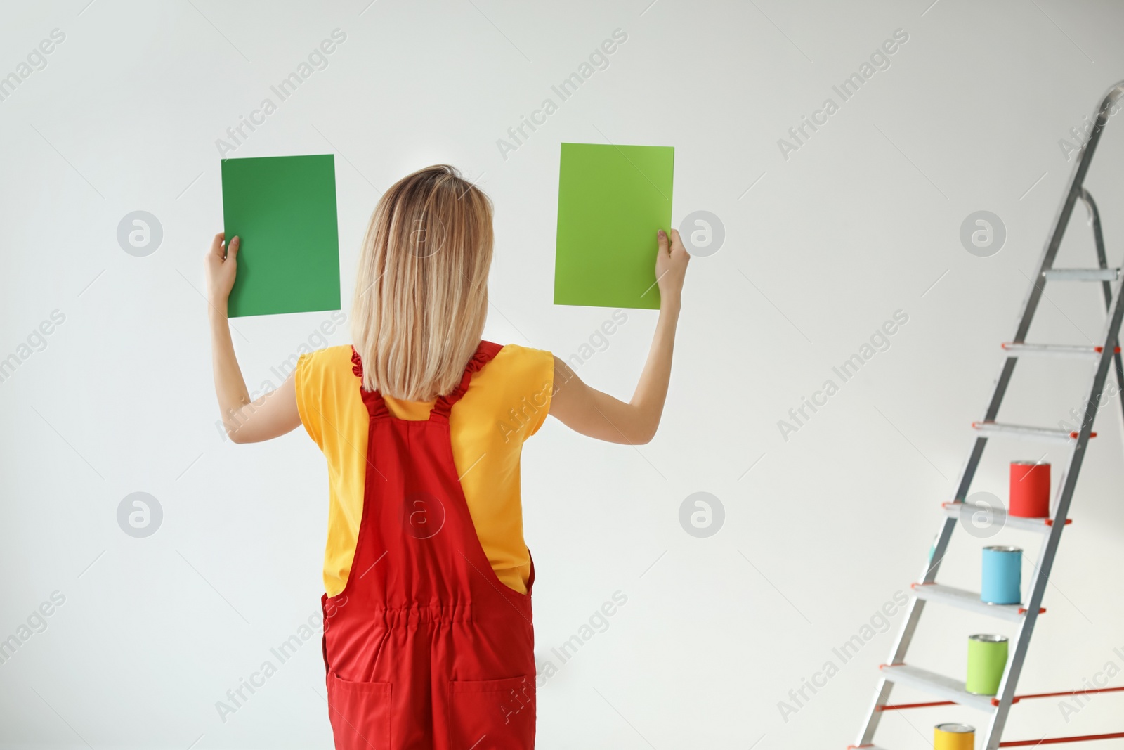 Photo of Young woman choosing color for wall on white background