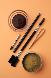 Photo of Flat lay composition with eyebrow henna and professional tools on orange background