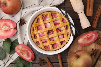 Flat lay composition with tasty apple pie, spices and fruits on wooden table