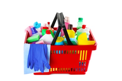 Photo of Shopping basket with different detergents, rag and gloves on white background