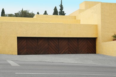 Building with wide wooden garage door. Exterior design