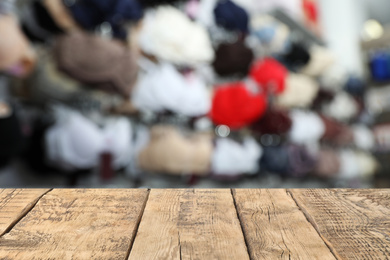 Image of Empty wooden table and blurred view of different underwear. Clothes shop