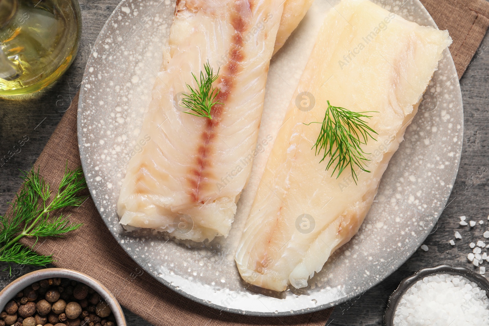 Photo of Pieces of raw cod fish and spices on table, top view