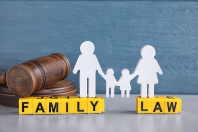 Cubes with letters, judge gavel and family figure on light table. Family law concept