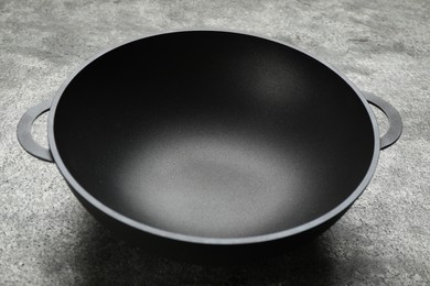 Empty iron wok on grey table. Chinese cookware