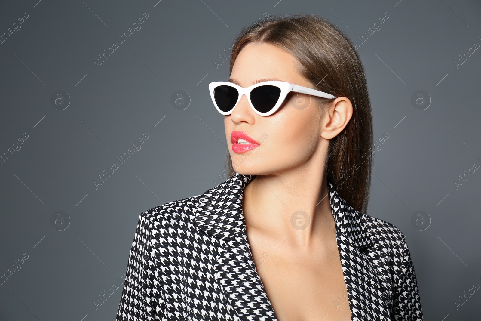 Photo of Young woman wearing stylish sunglasses on grey background