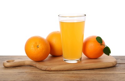 Fresh oranges and glass of juice on wooden table against white background