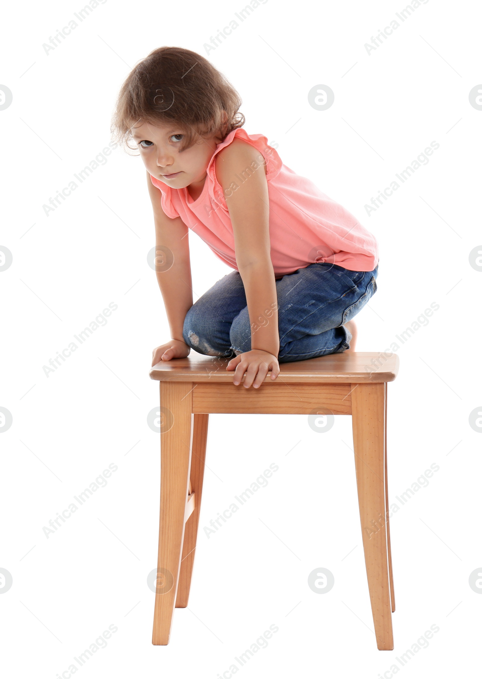 Photo of Little girl on stool against white background. Danger at home