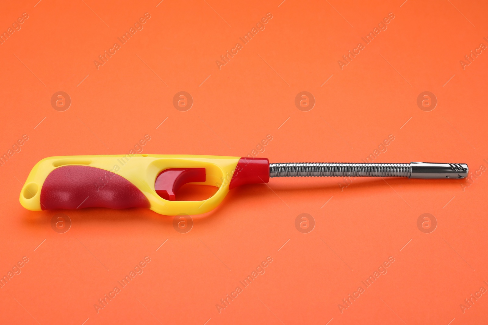 Photo of One bright gas lighter on orange background