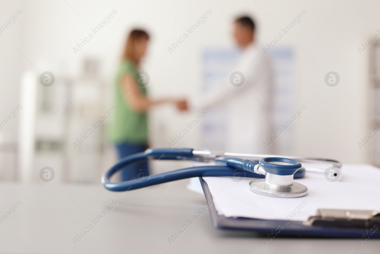 Photo of Clipboard and stethoscope on table in doctor's office. Patient consultation