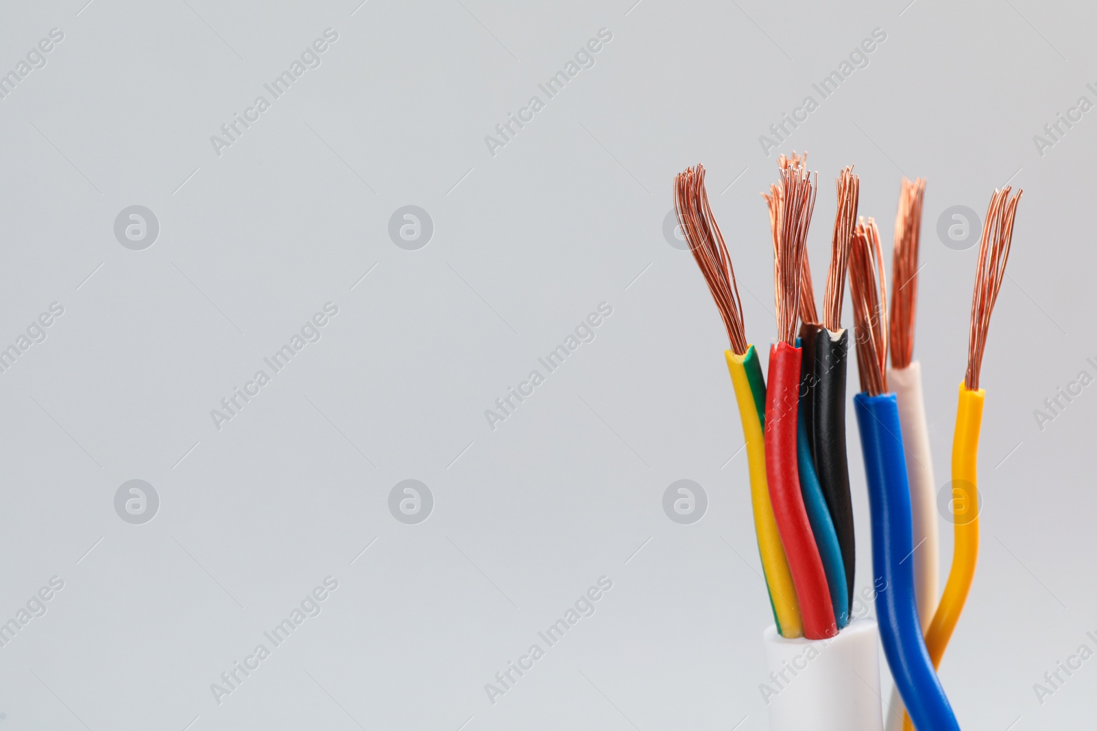 Photo of Many stripped electrical wires on light background, closeup. Space for text