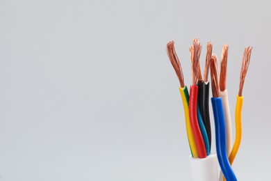 Many stripped electrical wires on light background, closeup. Space for text