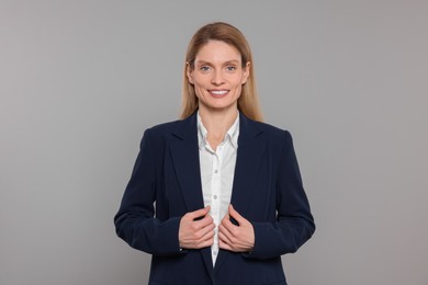 Happy real estate agent on grey background