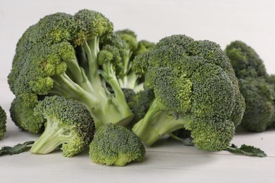 Photo of Fresh raw broccoli on white wooden table, closeup