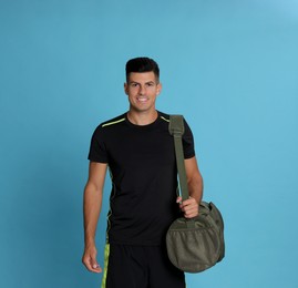 Photo of Handsome man with sports bag on light blue background