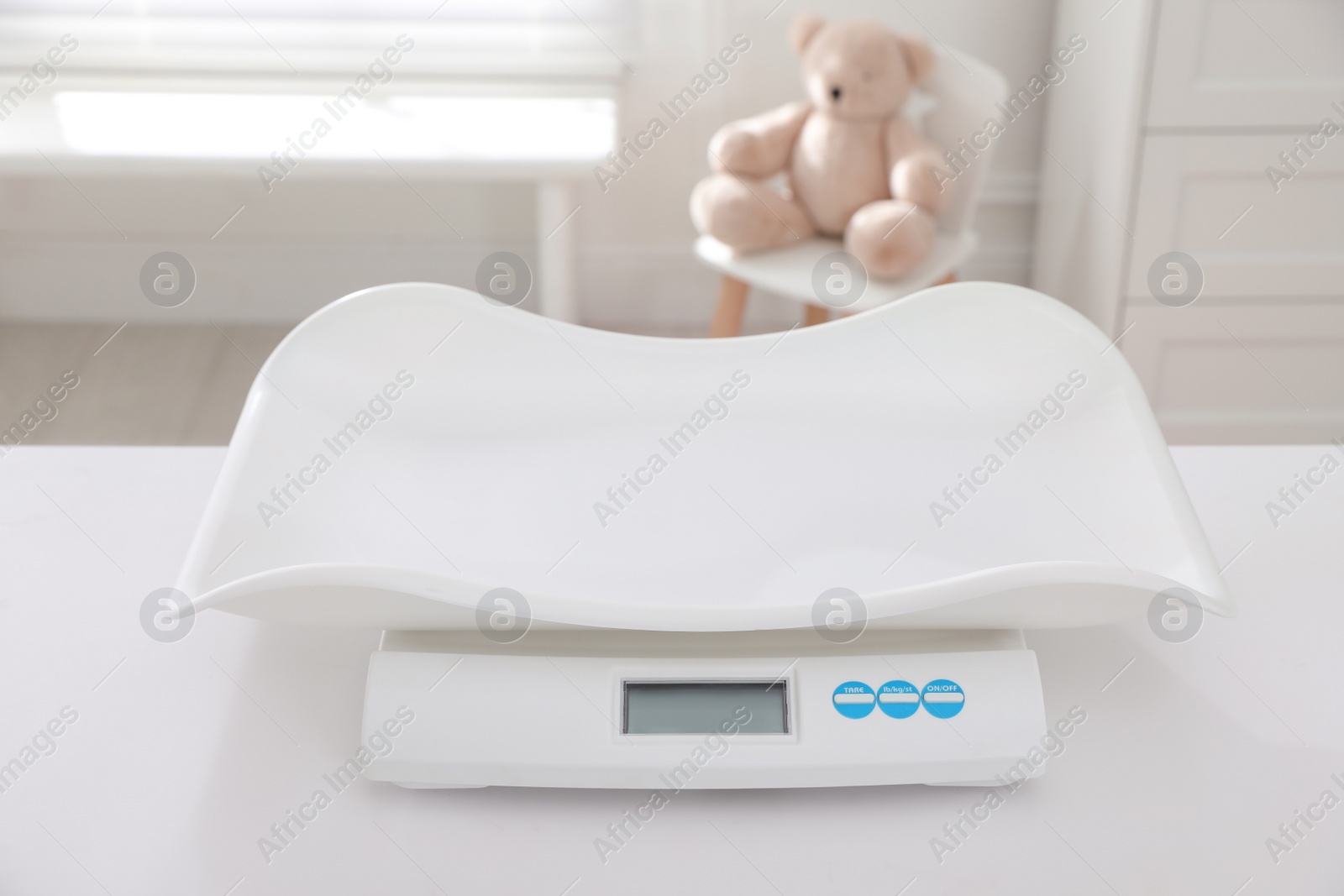 Photo of Modern digital baby scales on table in room