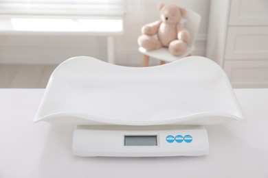 Modern digital baby scales on table in room