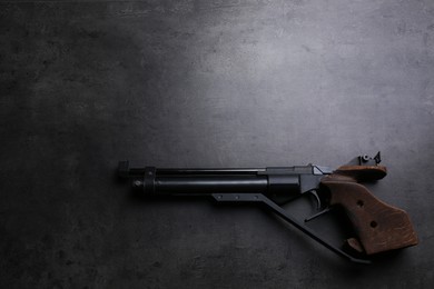 Photo of Sport pistol on black table, top view with space for text. Professional gun