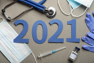 Photo of Flat lay composition with coronavirus vaccine and number 2021 on grey background