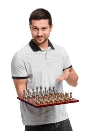 Smiling man showing chessboard with game pieces on white background
