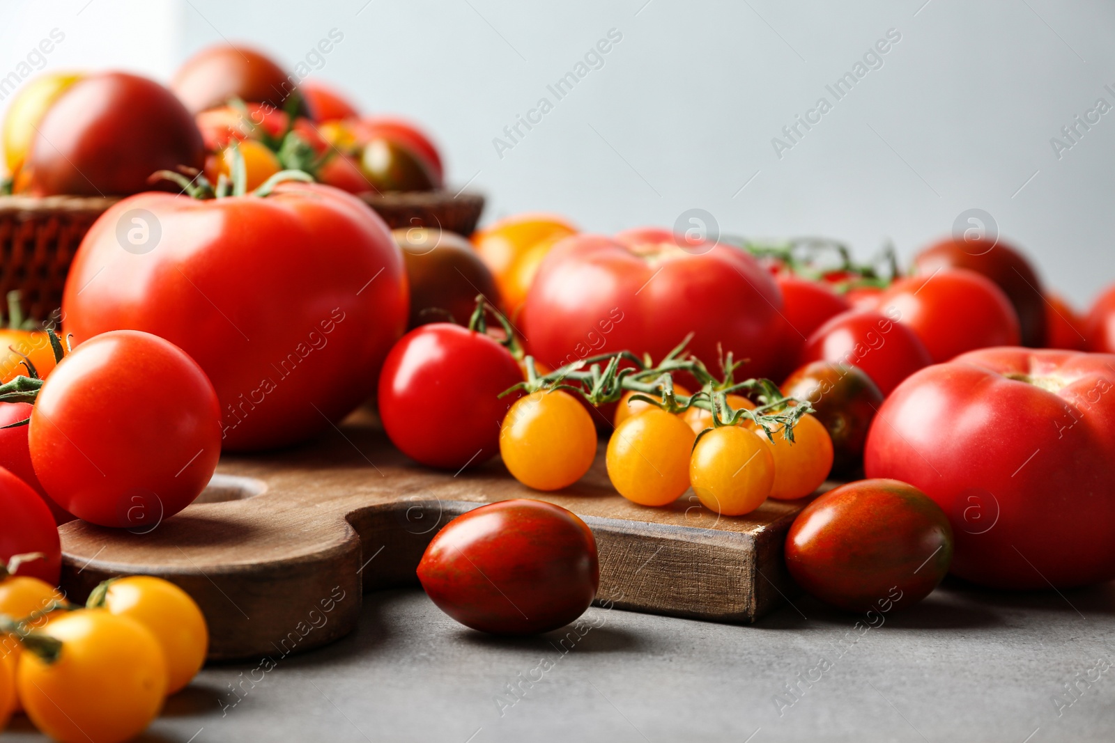 Photo of Many fresh ripe tomatoes on grey table